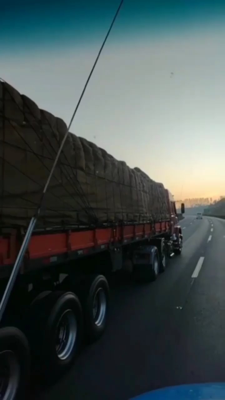 Carreta da TR Maizena carregada e encerada rodando em rodovia ao amanhecer