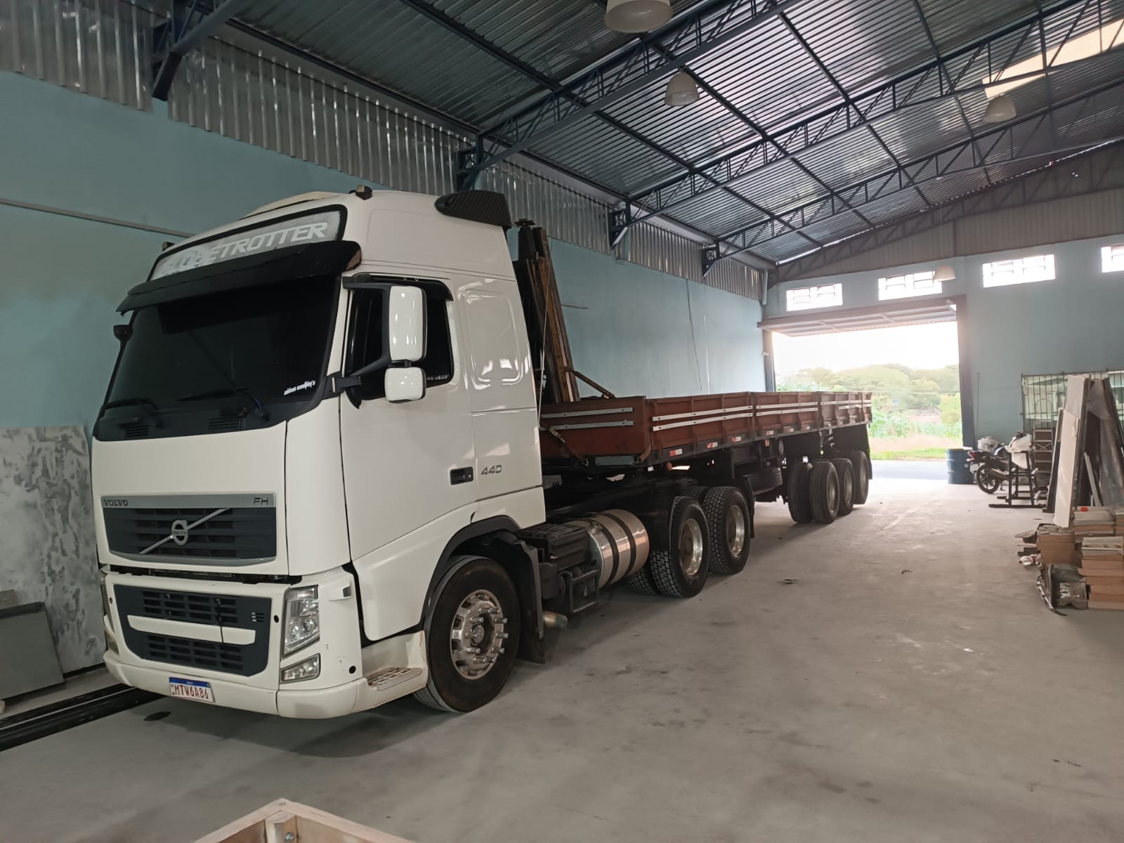 Volvo FH 440 com carreta dentro do galpão de carregamento