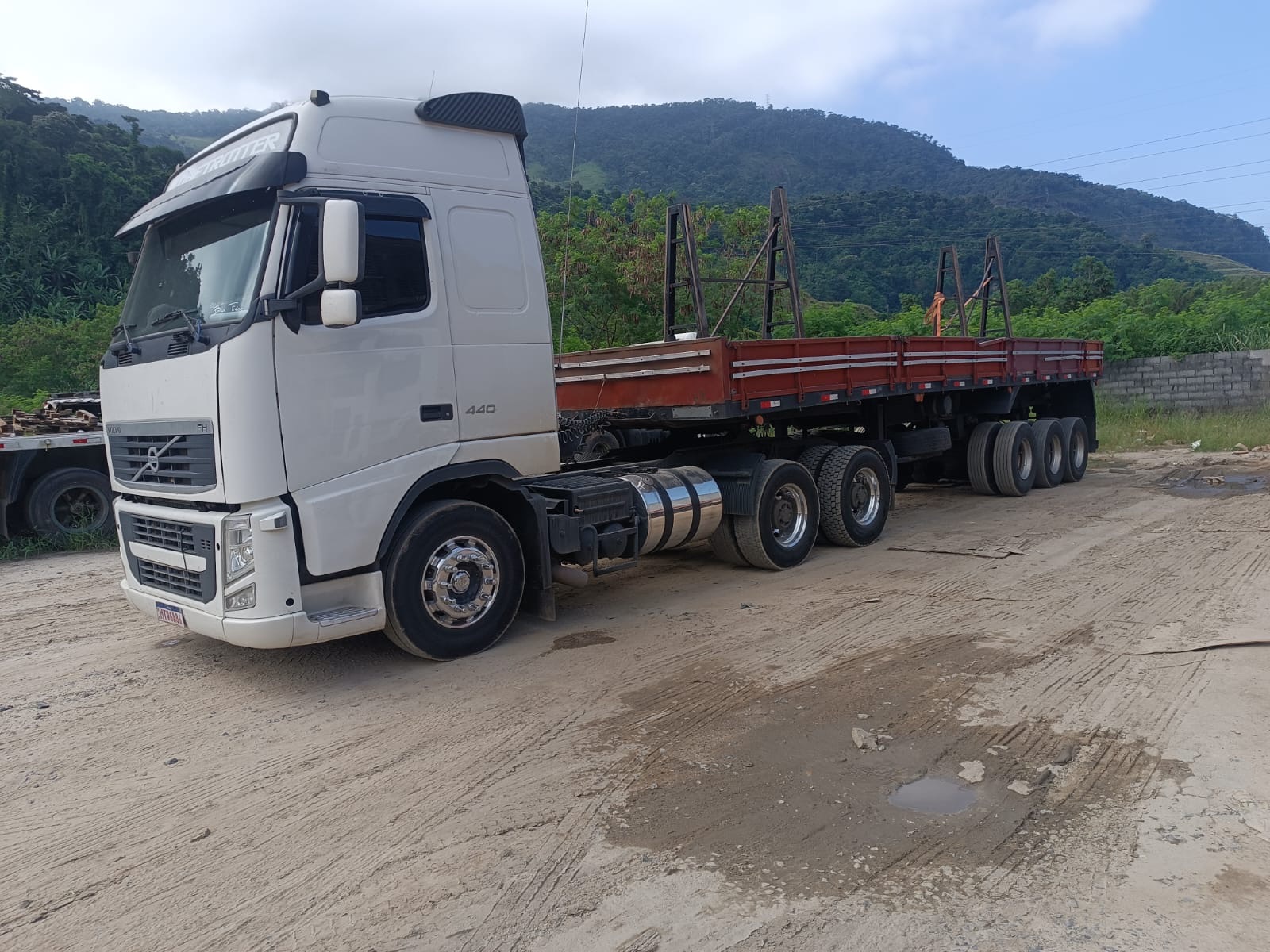 Volvo FH 440 da operação TR Maizena com carreta, serra ao fundo